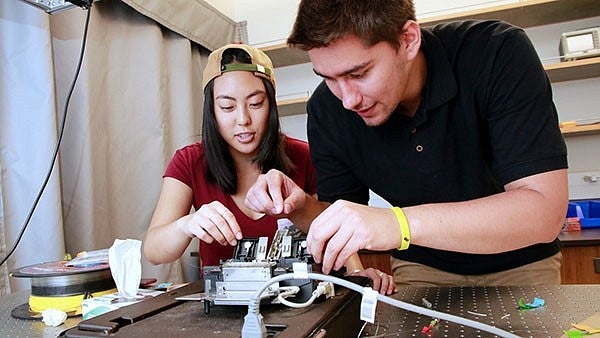 Students work together at optics table.