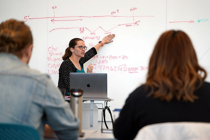 People sitting in a classroom listening to a teacher