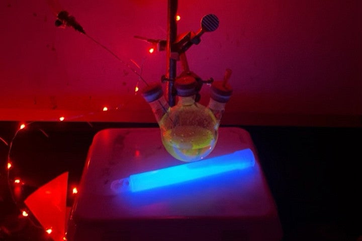 Chemicals lit up in different colors in a darkened lab