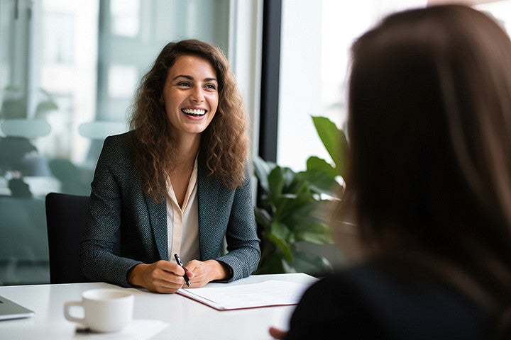 A woman smiling while talking to another person