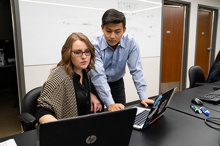 Two people work at a computer