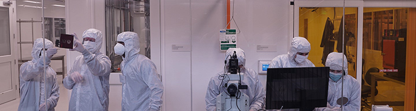 People in PPE gear in a clean room