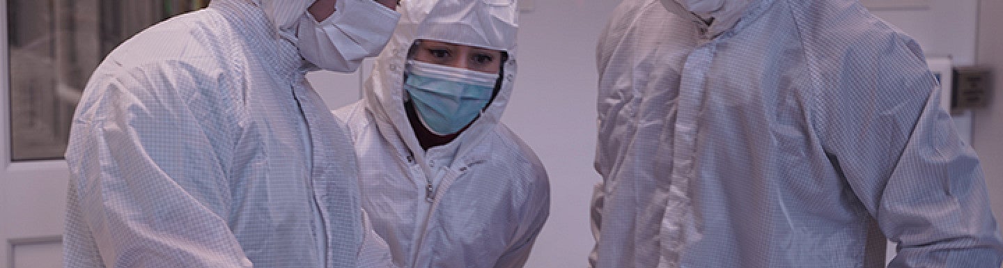 Three people in PPE gear in a lab