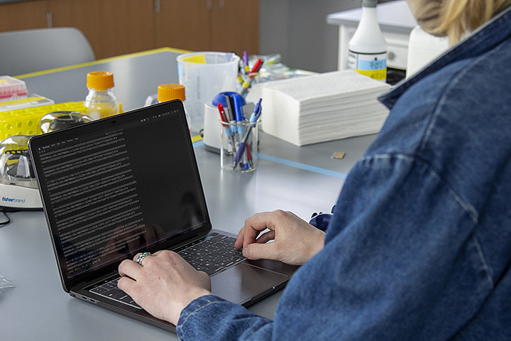 A person working on a laptop in a lab