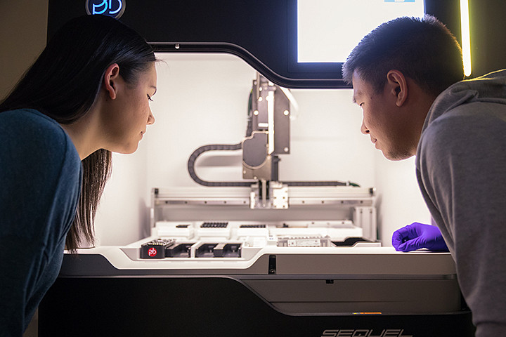 Two people looking at scientific equipment in a lab