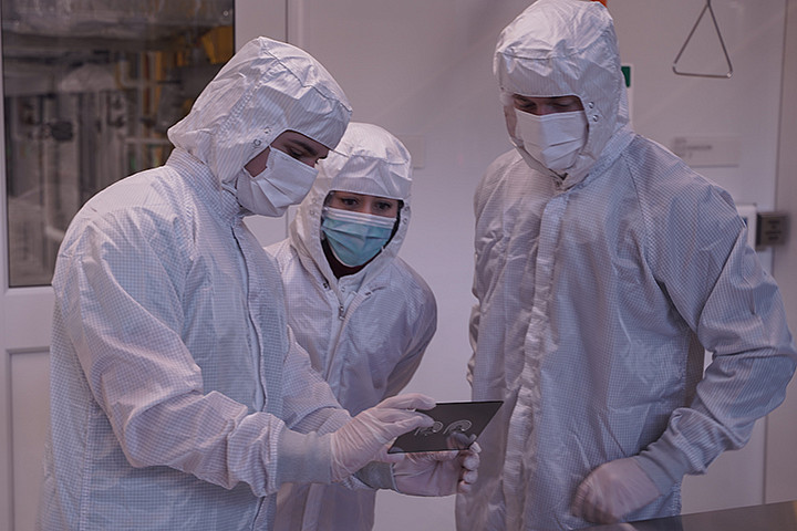 Three people in PPE gear in a lab
